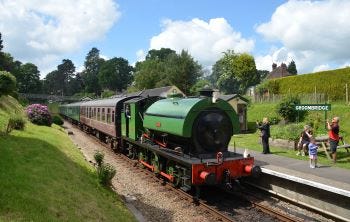 Green steam train pulling into the station 